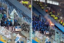 Scary moment Schalke hooligans kick through stadium barriers and set off fireworks over rival fans as match is delayed